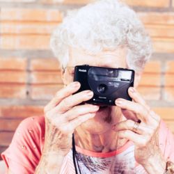 Persona mayor sacando una fotografía en Residencia Las Cumbres